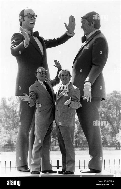 Eric Morecambe And Ernie Wise Standing Next To Statues Of Themselves At Battersea Park In London