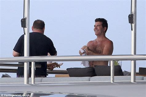 simon cowell takes to a jet ski while lauren silverman plays on the beach with their son eric
