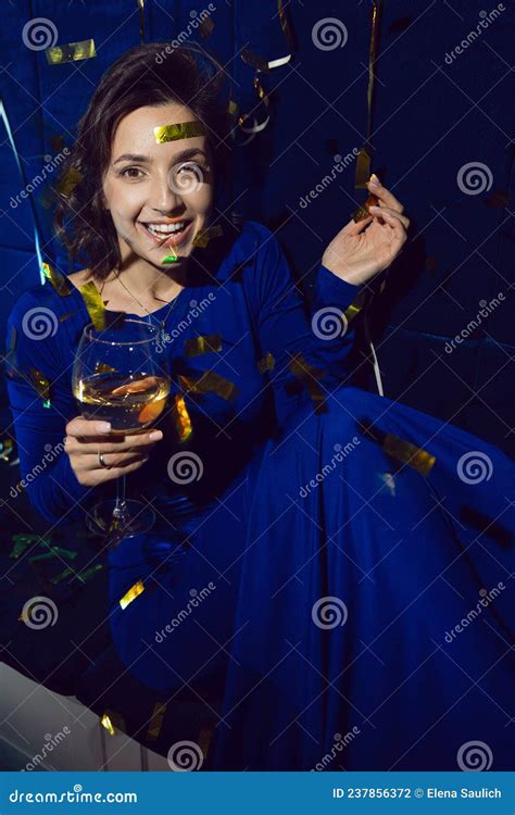 Cheerful Caucasian Brunette Girl In A Blue Dress With A Glass Of