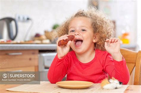 Adorable Girl Eating Sausage Superstock