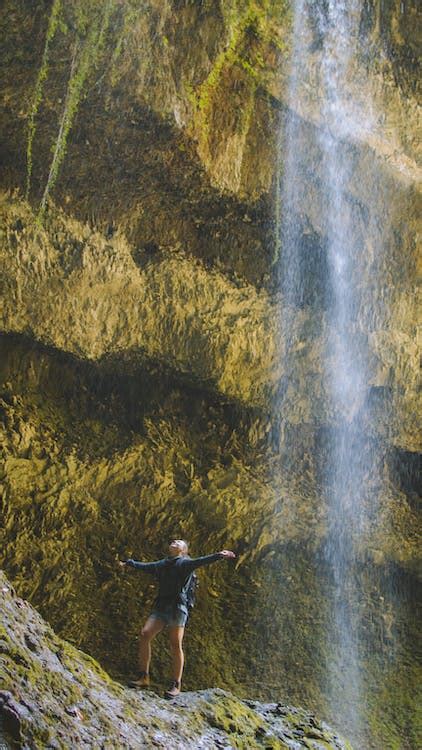 Woman Standing Under The Waterfalls · Free Stock Photo