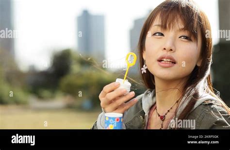 Attractive Young Japanese Girl Portrait Blowing Soap Bubbles Stock