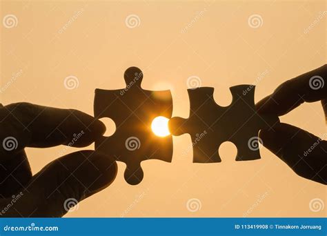 Two Hands Trying To Connect Couple Puzzle Piece With Sunset Background