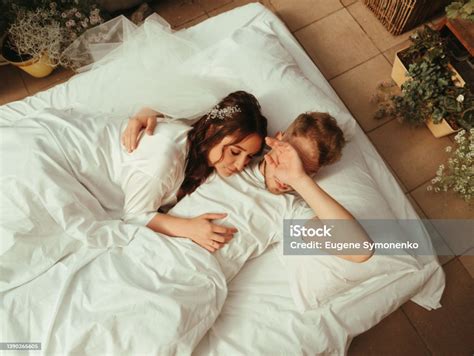 Loving Married Couple Lie On Bed In Hotel Relax Together Man And Woman