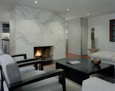 White marble combines with dark countertops and pendant lighting in the modern kitchen space below. 10 Beautiful Rooms with Marble Fireplaces