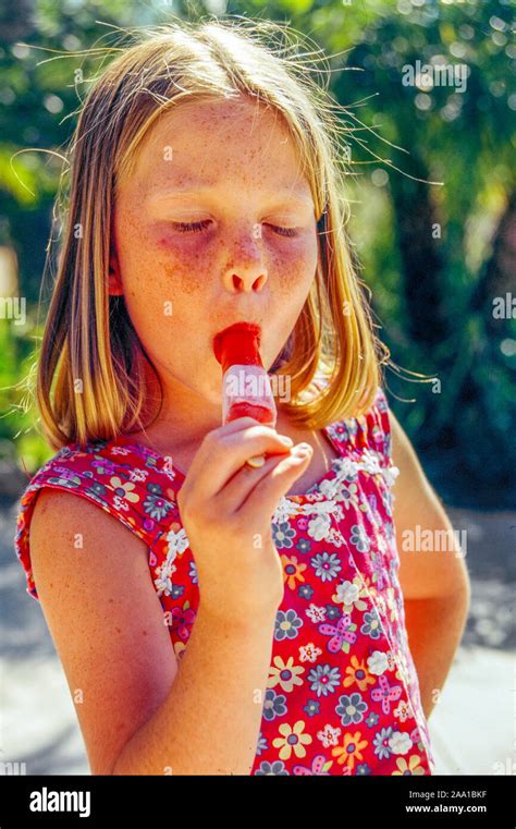 A 7 Year Old Girl Sucks A Popsicle On A Hot Summer Day In A Laguna
