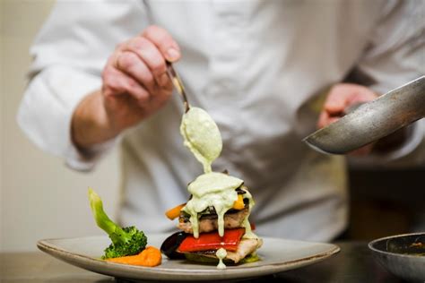 Premium Photo Chef Pouring Sauce Over Meal