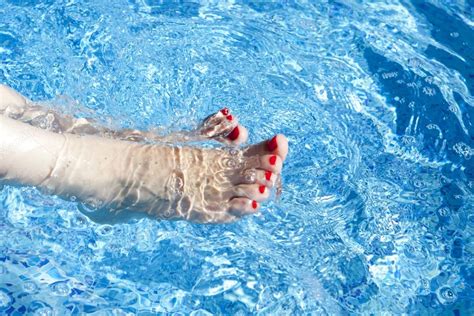 Sexy Women Legs Splashing In Tropical Swimming Pool — Stock Photo