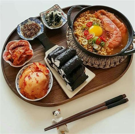 A Wooden Tray Topped With Different Types Of Food And Chopsticks On Top
