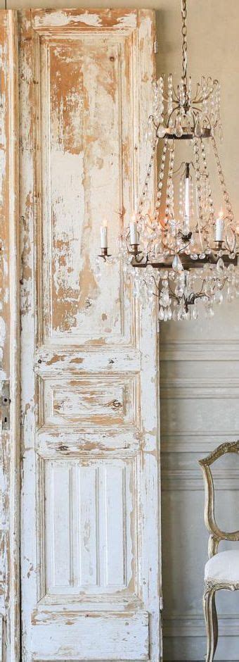 An Old White Door With A Chandelier Hanging From It S Side Next To A Chair