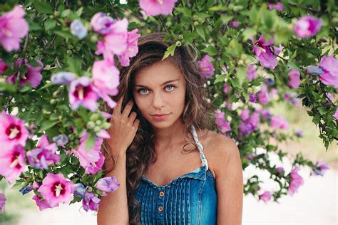 spring portrait of beautiful girl around purple flowers bush by stocksy contributor paff