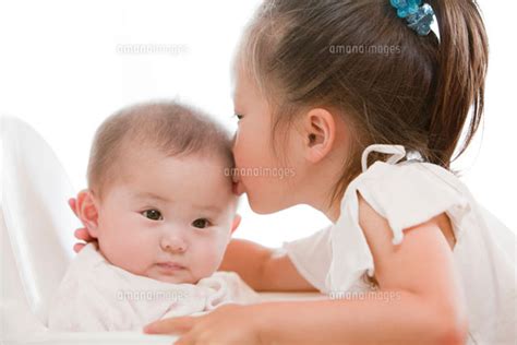 赤ちゃんのおでこにキスをする女の子 22946001531 ｜ 写真素材・ストックフォト・画像・イラスト素材｜アマナイメージズ