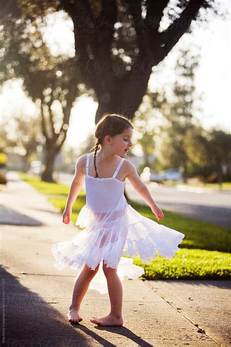 Young Girl Wearing White Slip Dress Twirling On Sidewalk By Dina Marie Giangregorio