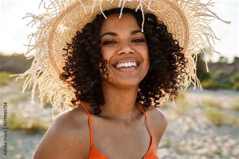 Cheerful Young African Woman Walking At The Beach Outside Stock Photo