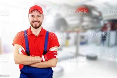 Happy Auto Mechanic Standing In Car Service Garage Stock Photo
