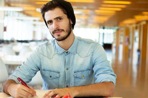 Joven Estudiante Masculino Estudiando En La Biblioteca Foto Premium