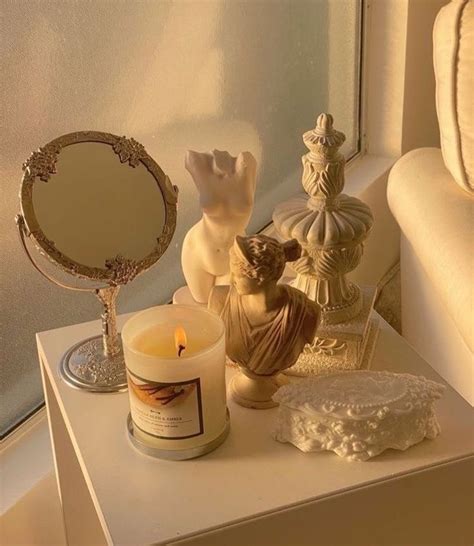A White Table Topped With A Candle Next To A Mirror And Other Items On