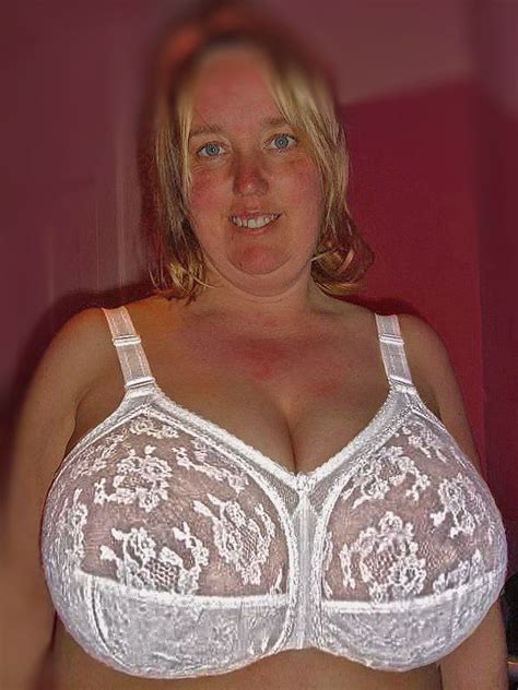 A Woman Wearing A White Bra With Lacy Garter On Her Chest Is Posing For