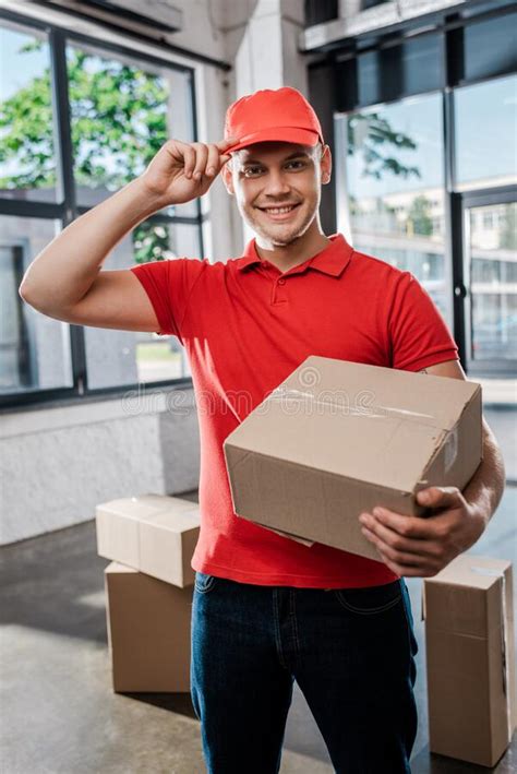 Happy Delivery Man Touching Cap While Stock Photo Image Of Windows