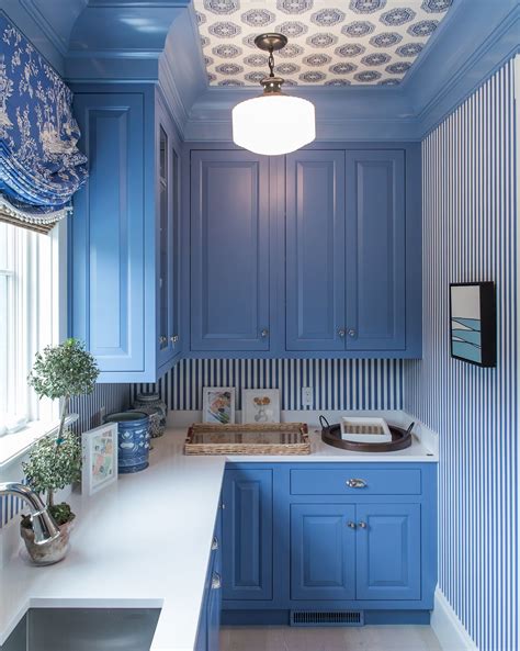 A Kitchen With Blue Cabinets And White Counter Tops