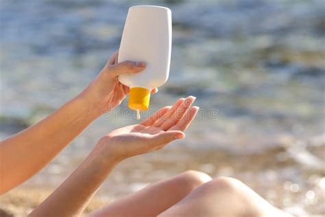 Woman Hands Putting Sunscreen From A Bottle On The Beach Stock Image