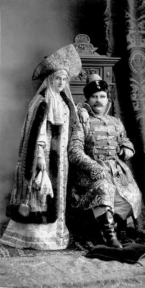 An Old Black And White Photo Of Two People Dressed In Historical