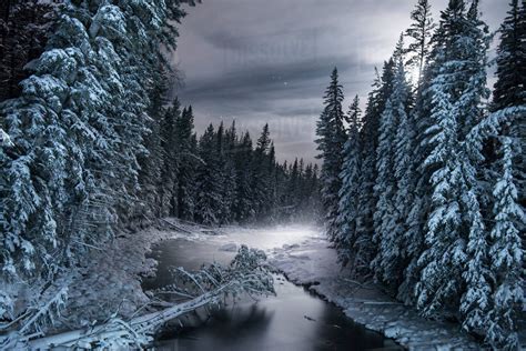 Scenic View Of Frozen River Amidst Snow Covered Trees Stock Photo