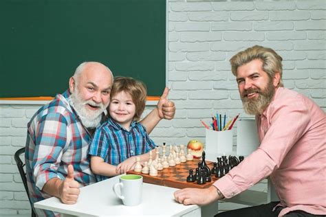 Premium Photo Father And Son With Grandfather Playing Chess Back To
