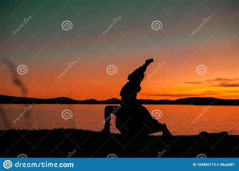 Silhouette Of A Girl In A Dress In A Yoga Pose On The