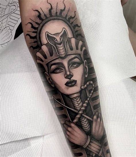 A Womans Arm With An Egyptian Tattoo Design On The Left Forearm And Hand