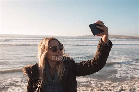 Woman Taking Selfie With Mobile Phone At Beach On A Sunny Day — Holding