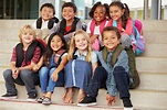A group of elementary school kids sitting on school steps - Stock Photo ...