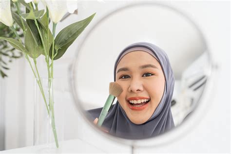 Beautiful Asian Young Muslim Woman Looking In The Mirror And Applying