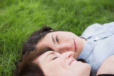 A Same Sex Couple Two Women Lying On The Grass Looking Tenderly At
