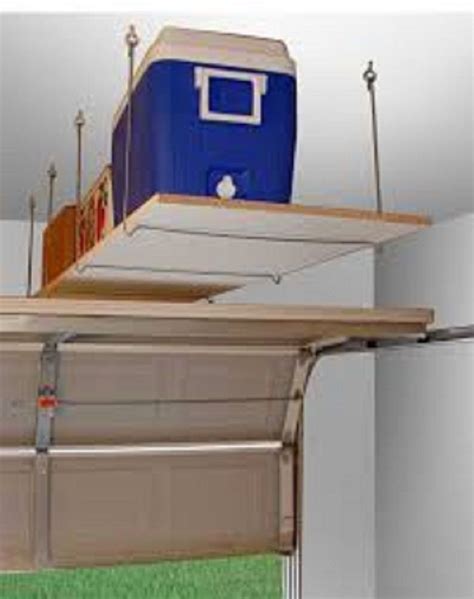 Overhead garage storage systems are an ideal solution for getting your things off of the floor and out of sight. Creative Simple Floating DIY Shelving Unit Above Garage Door To Hold Functional Boxes With Lots ...