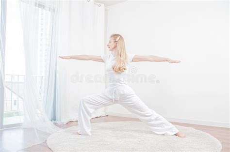 Beautiful Woman Is Practicing Yoga At Home Girl Doing Virabhadrasana