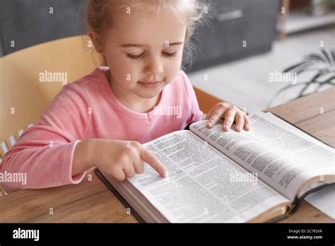 Little Girl Reading Bible At Home Stock Photo Alamy