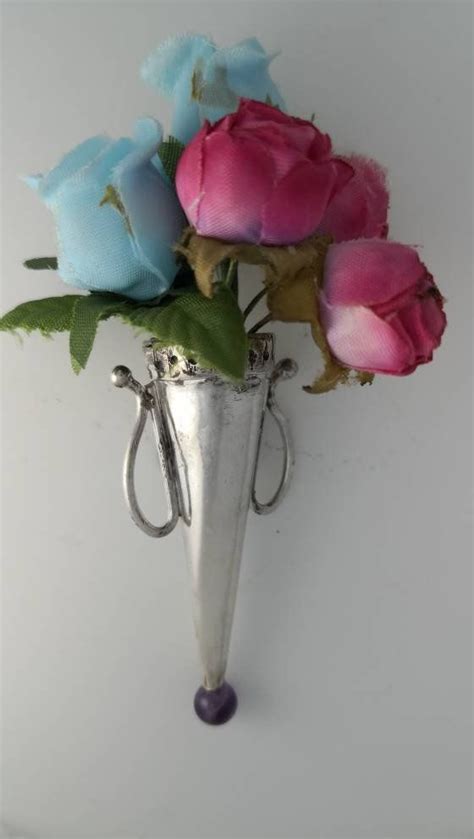 A Silver Vase Filled With Pink And Blue Flowers