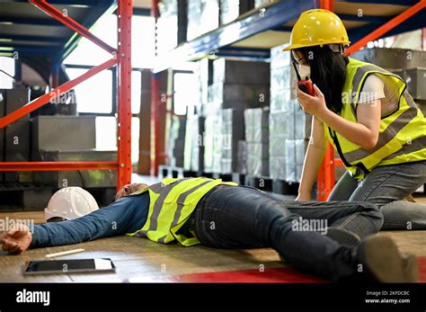 Unconscious Asian Warehouse Male Worker Getting First Aid By His Female