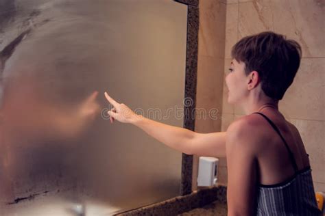 A Woman Draws A Heart In The Mirror The Heart Is Fingerprinted On The Glass In Bathroom People