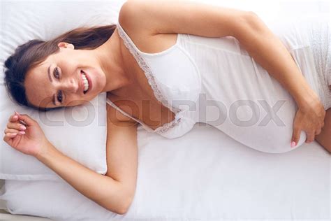 Cheerful Pregnant Woman Lying On White Sheet In Bed Stock Image Colourbox