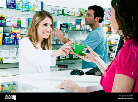 Female Pharmacist Giving Medicine To A Customer Stock Photo Alamy