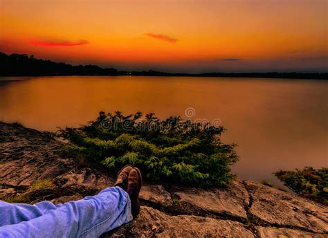 Relaxing Under An Orange Sunset Over A Calm Lake Stock Photo Image Of