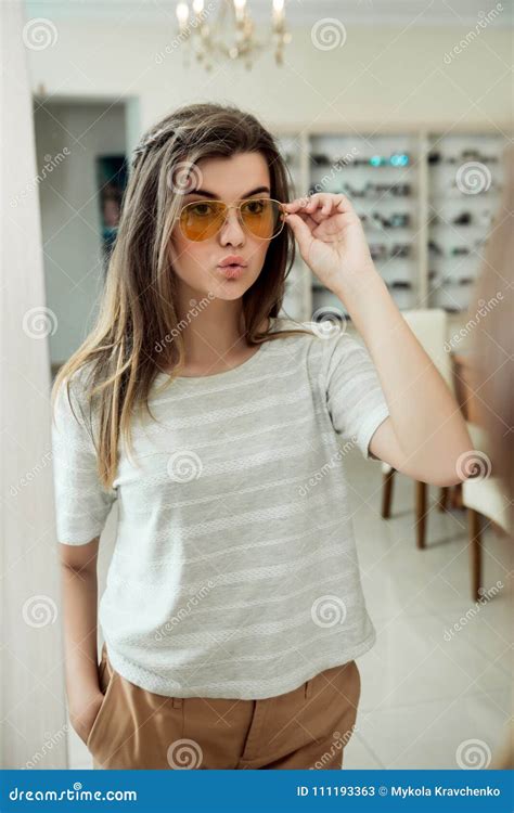 Attractive Confident Girl Trying On Stylish Eyewear While On Shopping
