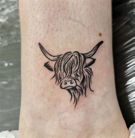 A Black And White Photo Of A Cows Head On The Ankle Tattoo Design