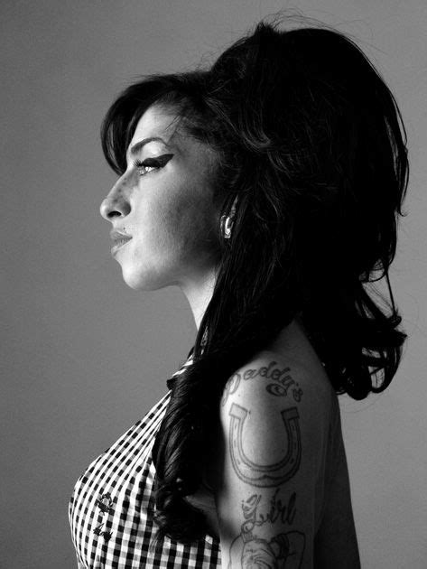 A Woman With Tattoos On Her Arm And Shoulder Looking Off To The Side