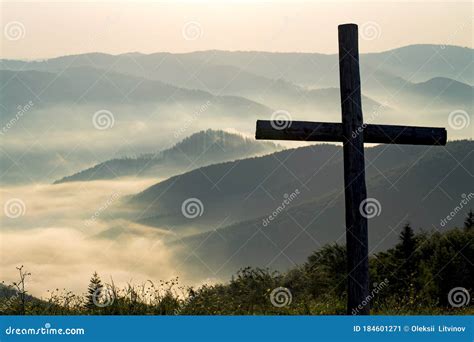 Christian Cross On A Background Of Fog Covered Mountains At Dawn Stock