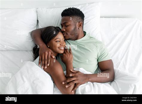 Cheerful Young African American Husband Hugging Wife And Kissing On