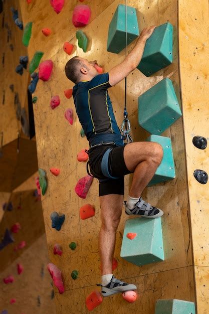 Premium Photo Man Rock Climbing Indoors In The Arena
