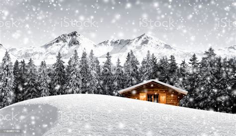 Log Cabin In Snowy Mountain Landscape Stock Photo